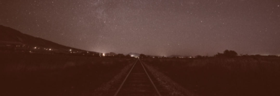 An image of railroad tracks going off into the distance, maybe to an adventure